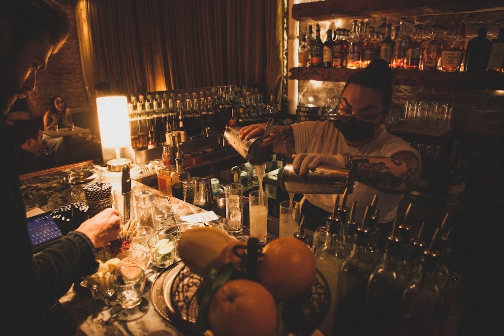 waitress pouring a cocktail at Subject bar NYC
