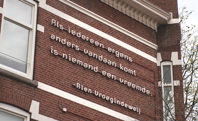 a quote by poet Rien Vroegindeweij on a brick building in Rotterdam