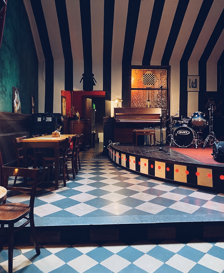 Stage and door to bathrooms at cafe Het Damberd in Ghent