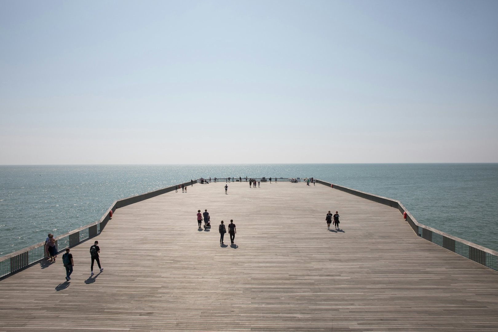 People walking on a sunny Hastings Pier