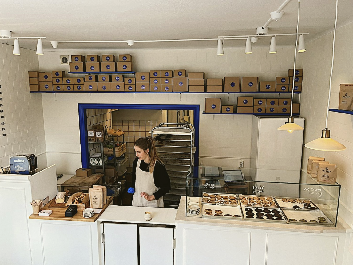 A woman selling cookies behind the counter at Krümel cookie shop