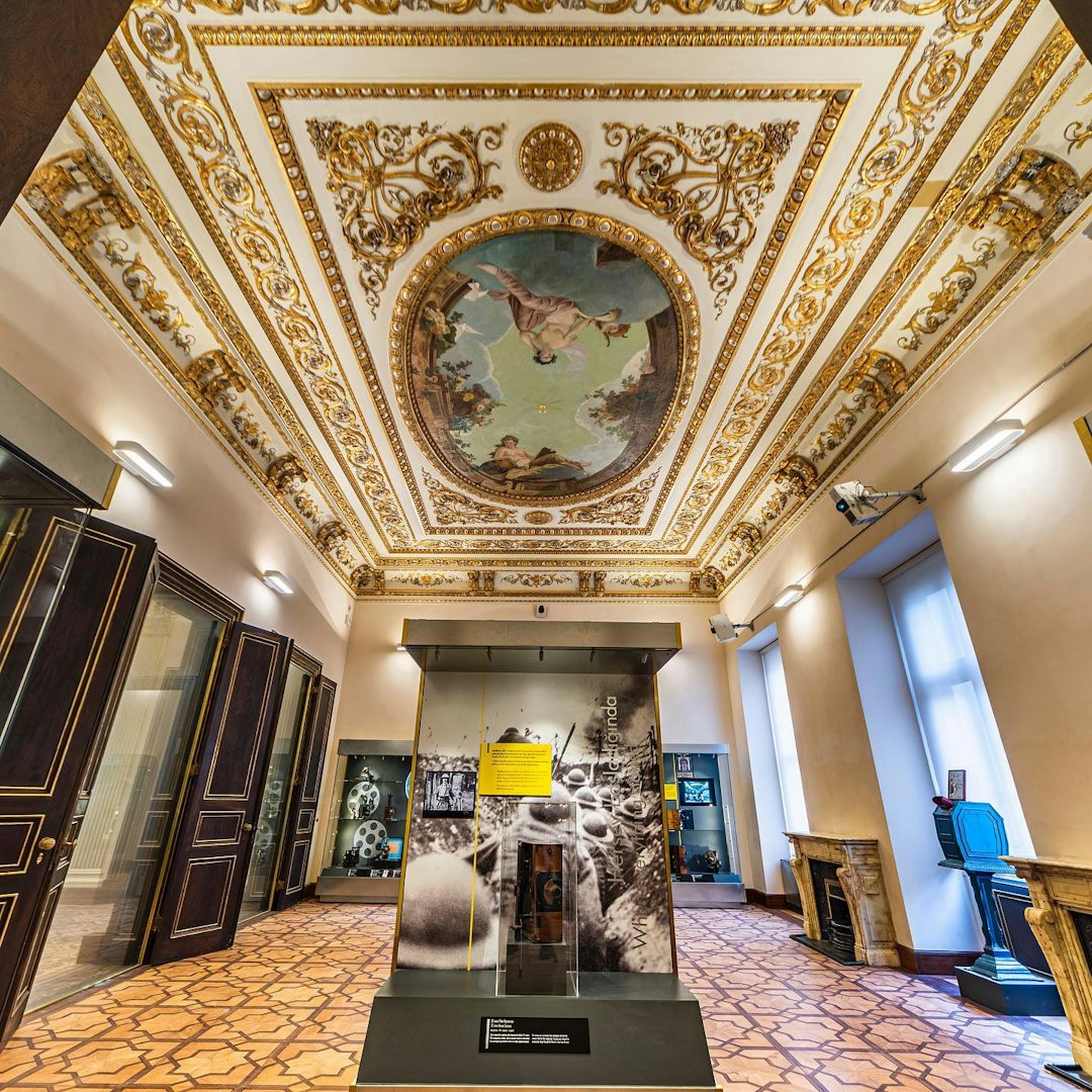 Lavish room with ornate ceiling and display cases at Istanbul Cinema Museum