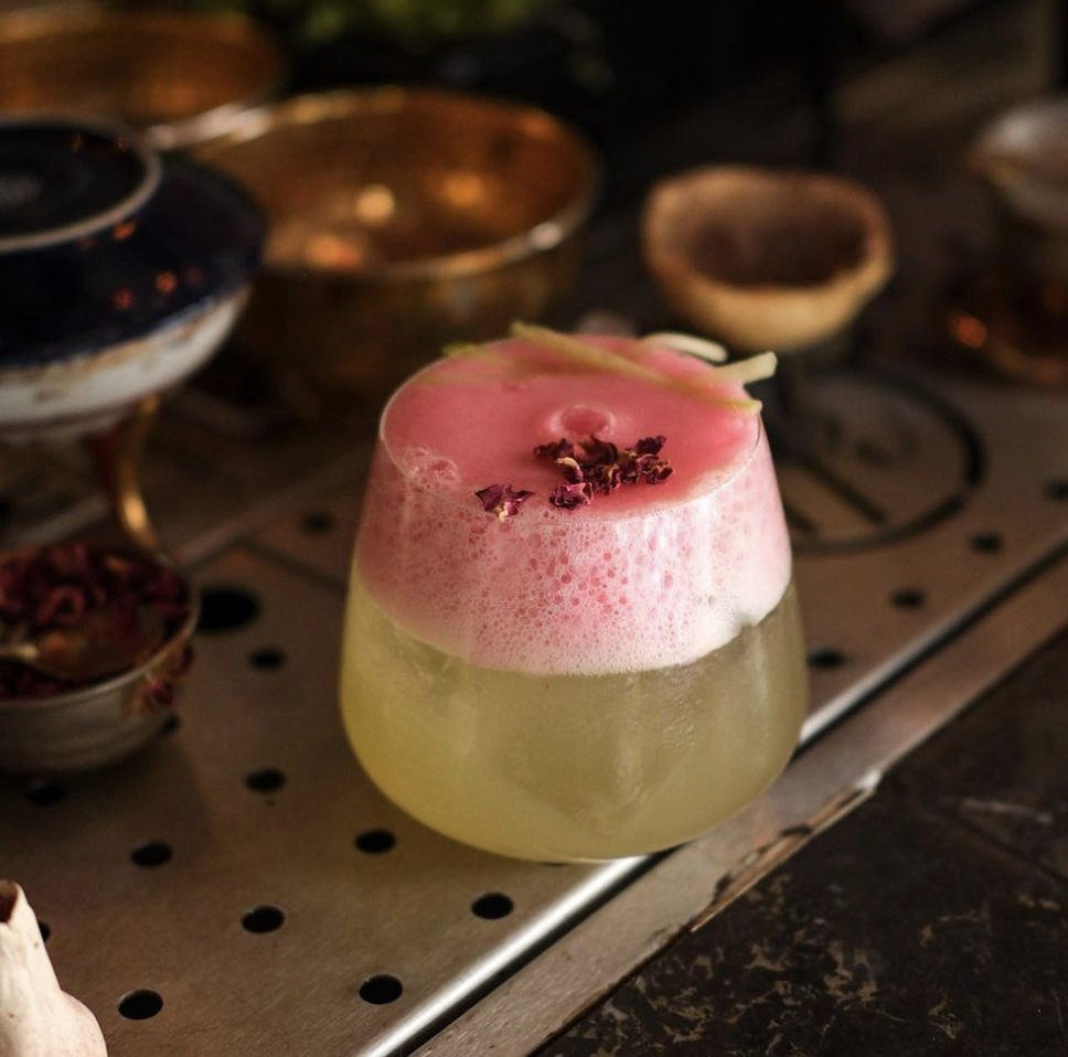 A cocktail with pink foam on top at Fahri Konsolos