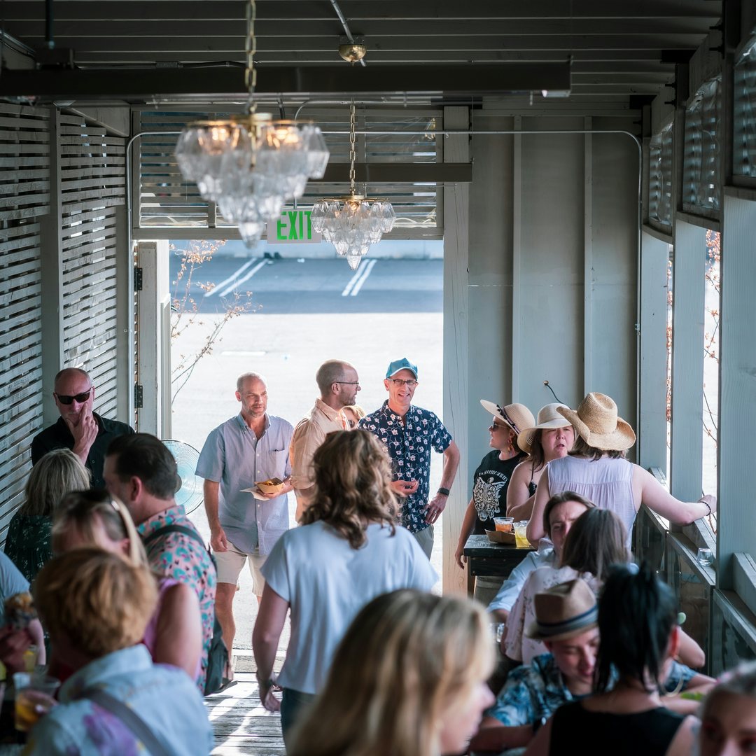 People drinking and talking at Fast Penny Spirits Tasting Deck