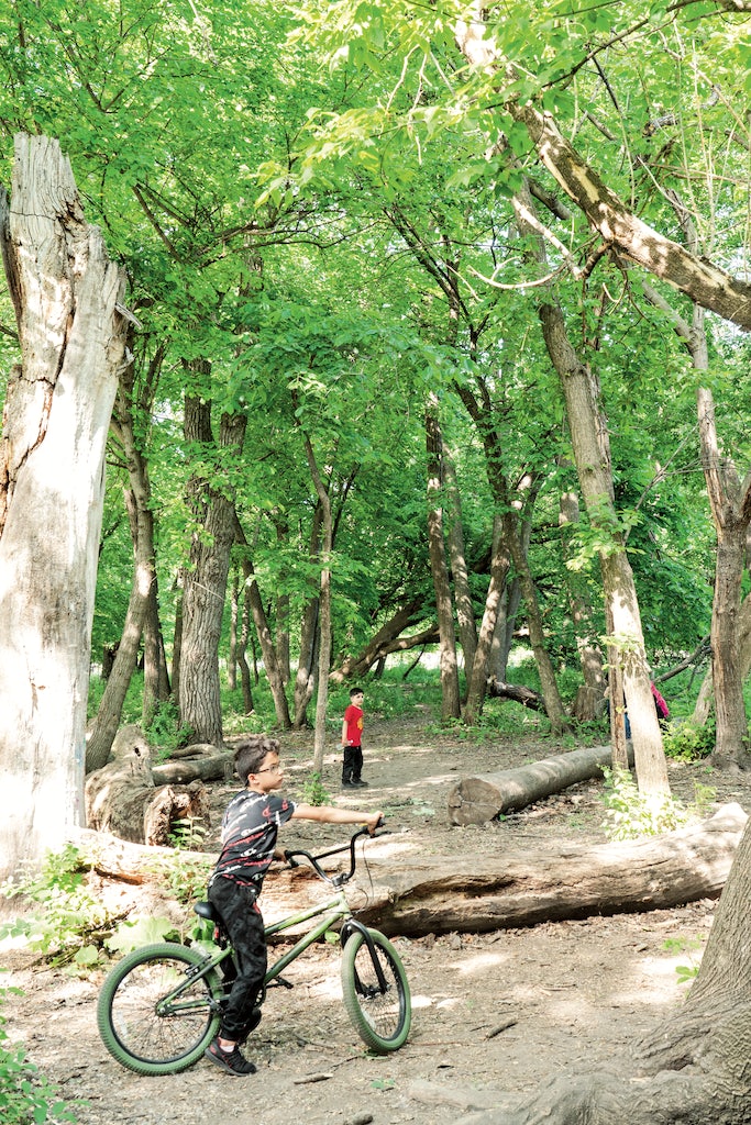 a child enjoying the trail with a bike in LaBagh Woods