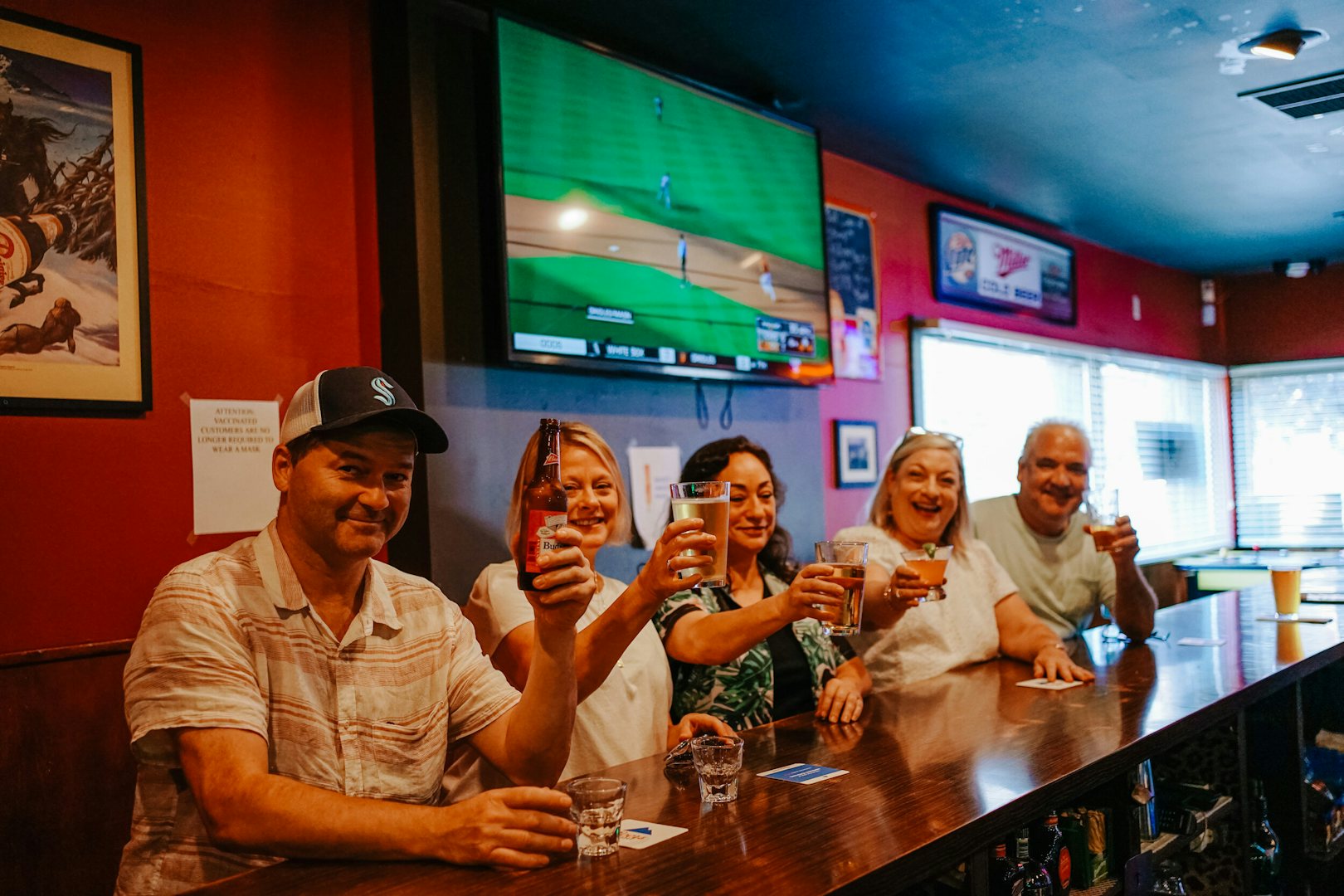 5 locals sitting at the bar with a beer at Targy's tavern