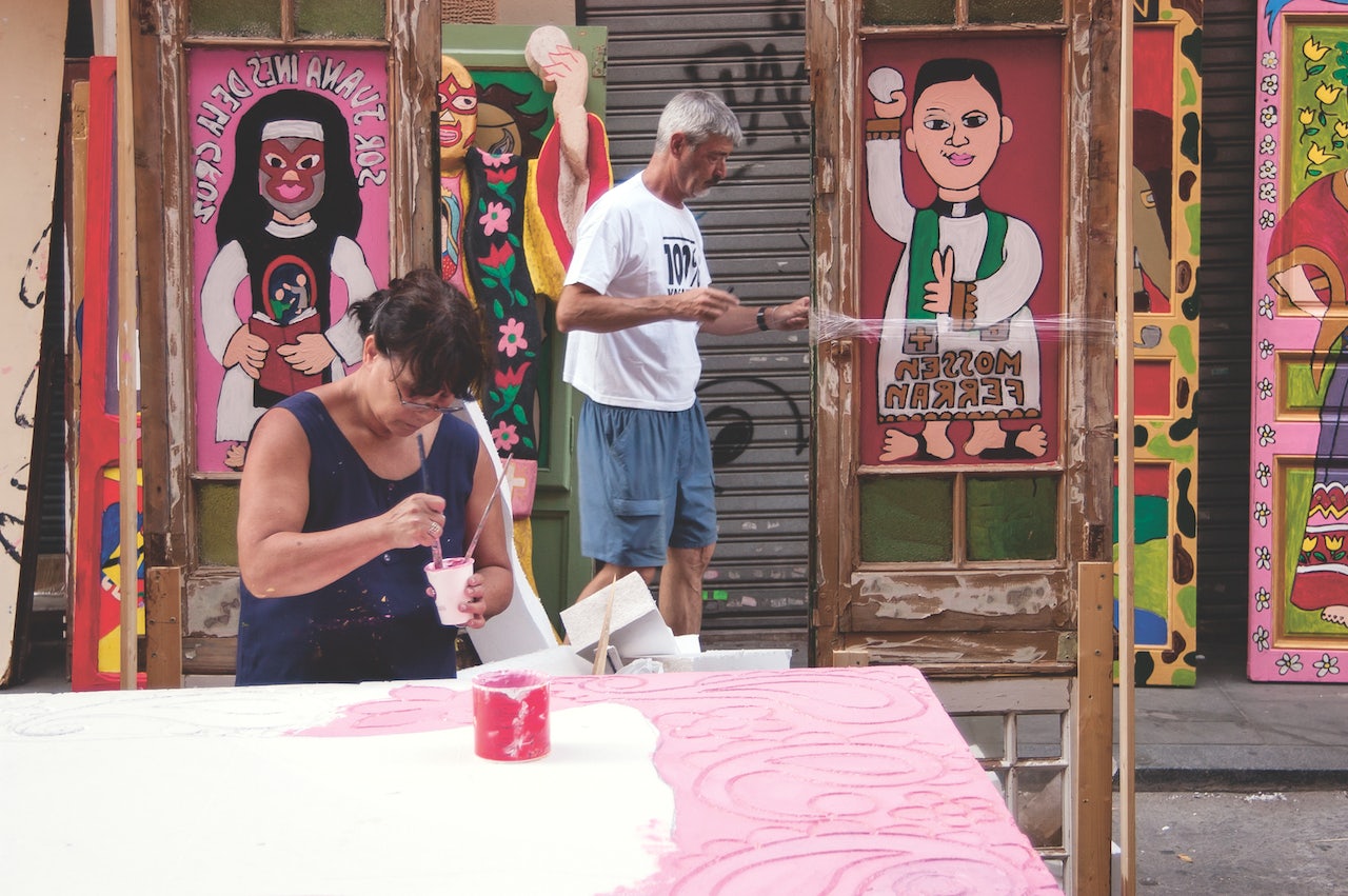 people decorating the street of Gracia with paintings for the festa major de gracia