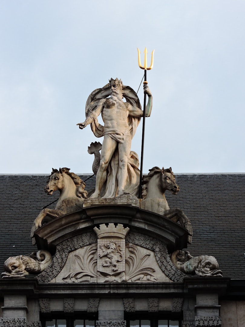 a statue of poseidon with his trident on top of the Vismijn in Ghent