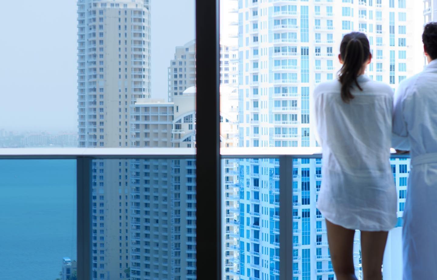 a couple enjoying the view from their room balcony at the Kimtpon Epic Hotel
