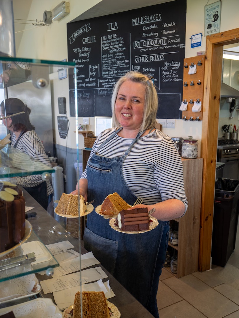 Server with slices of homemade cake at the Birsay Bay Tearoom