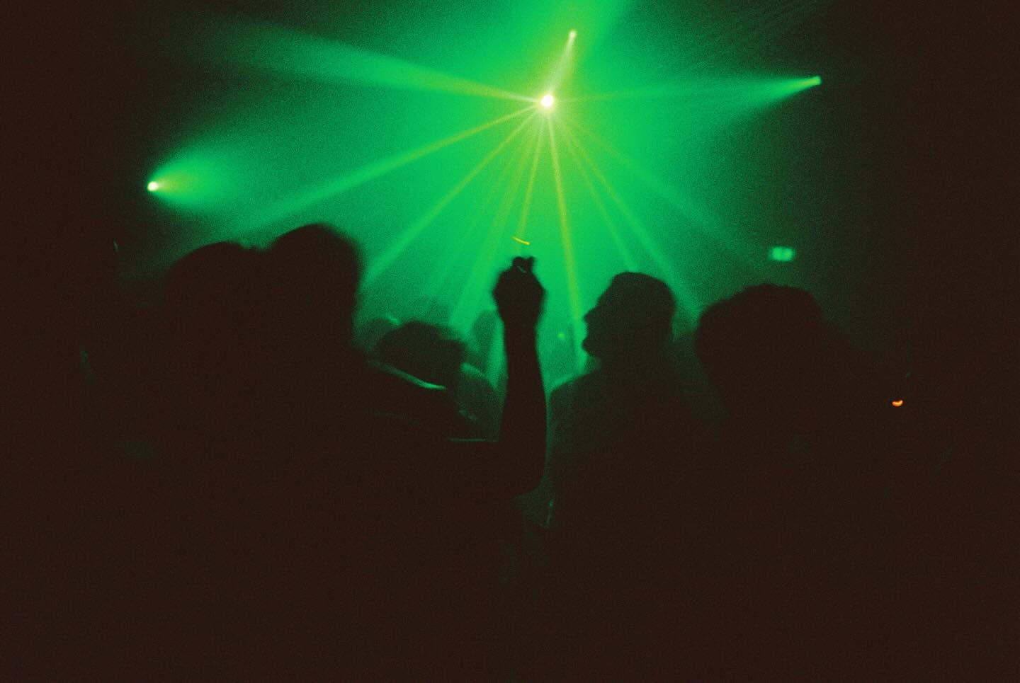 people dancing against green strobelights